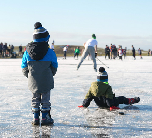children sitting on ice rink