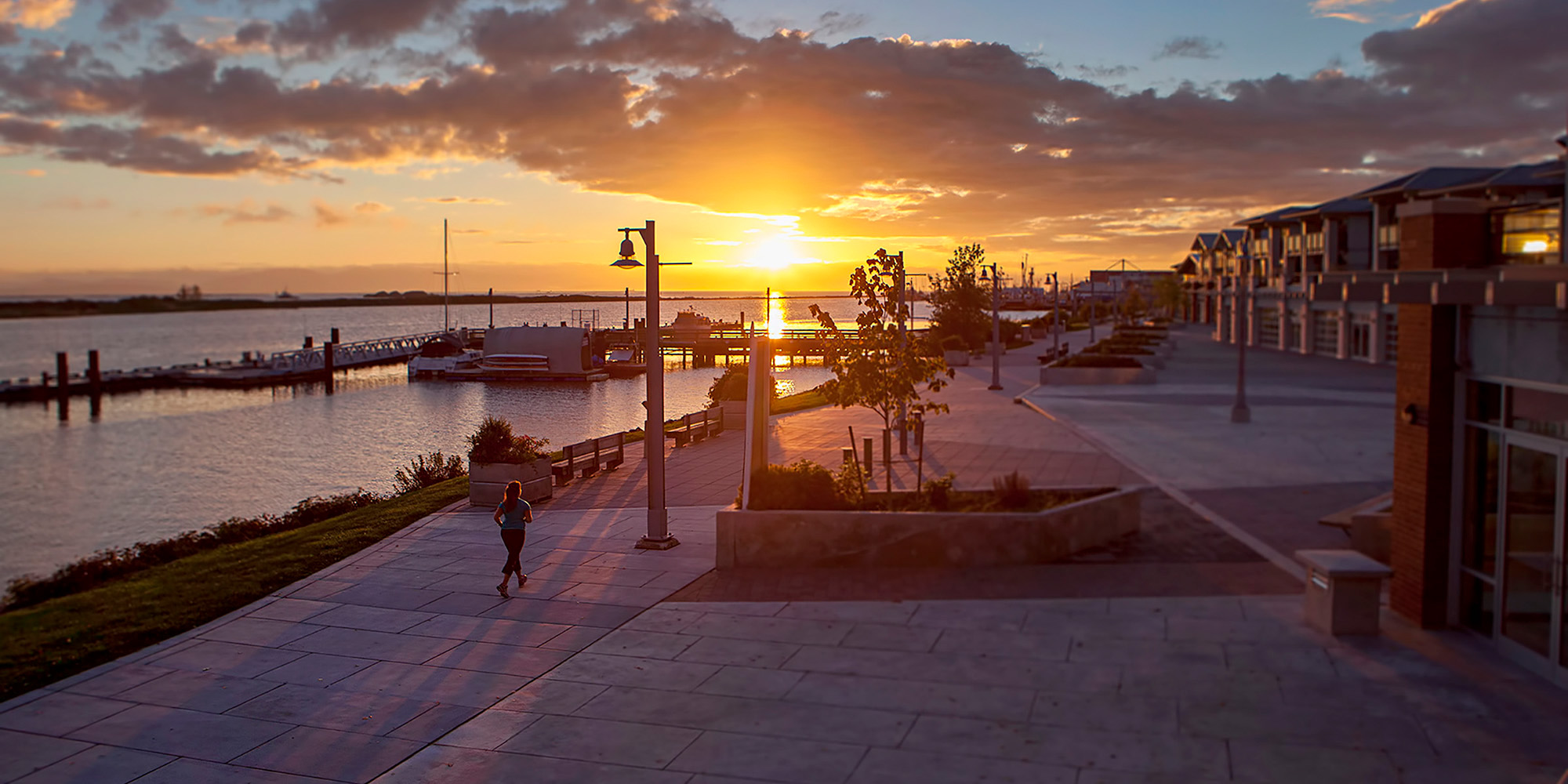 Woman running along the boarwalk at sunset